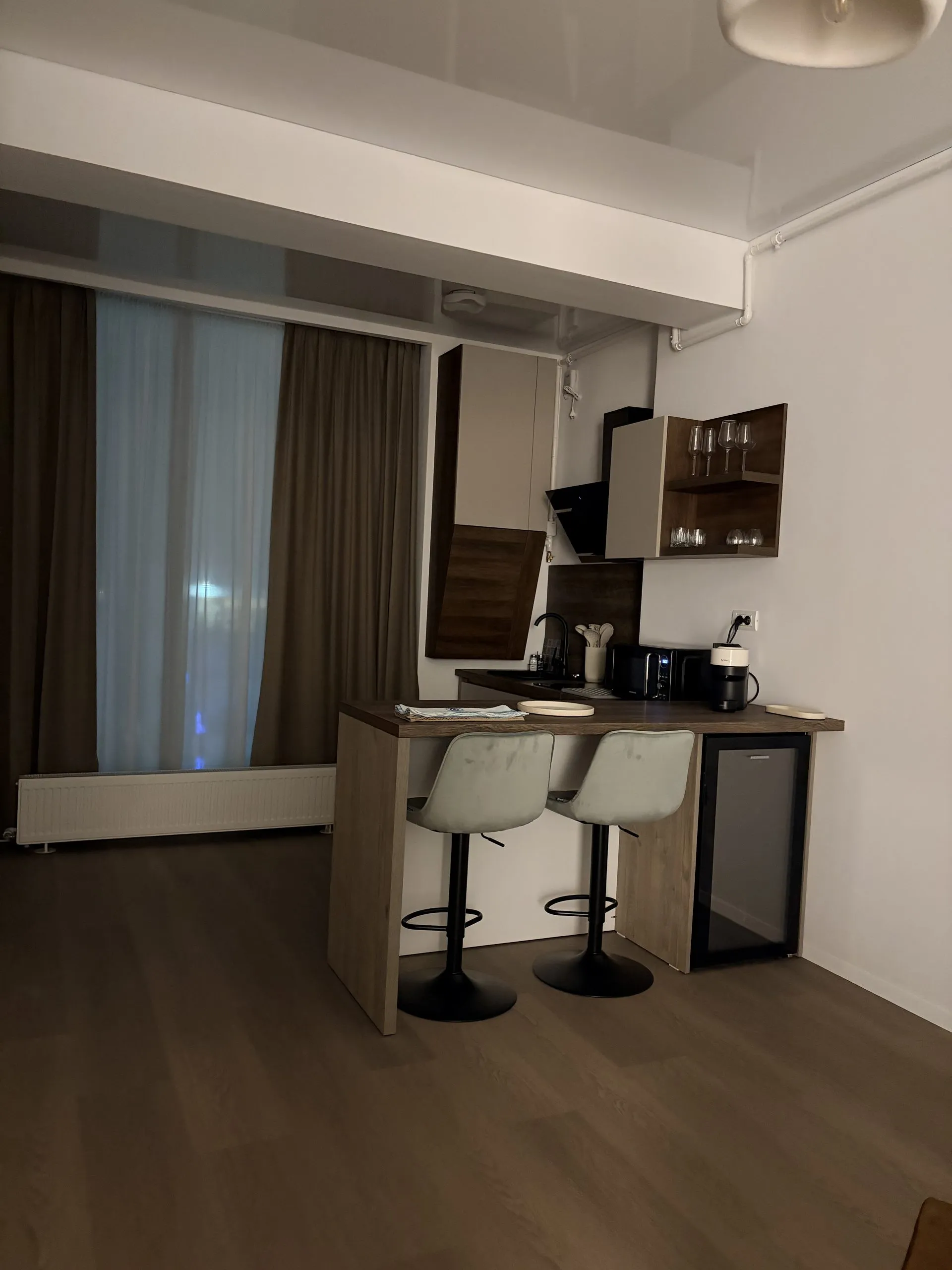 Kitchenette and breakfast bar with two stools in the evening