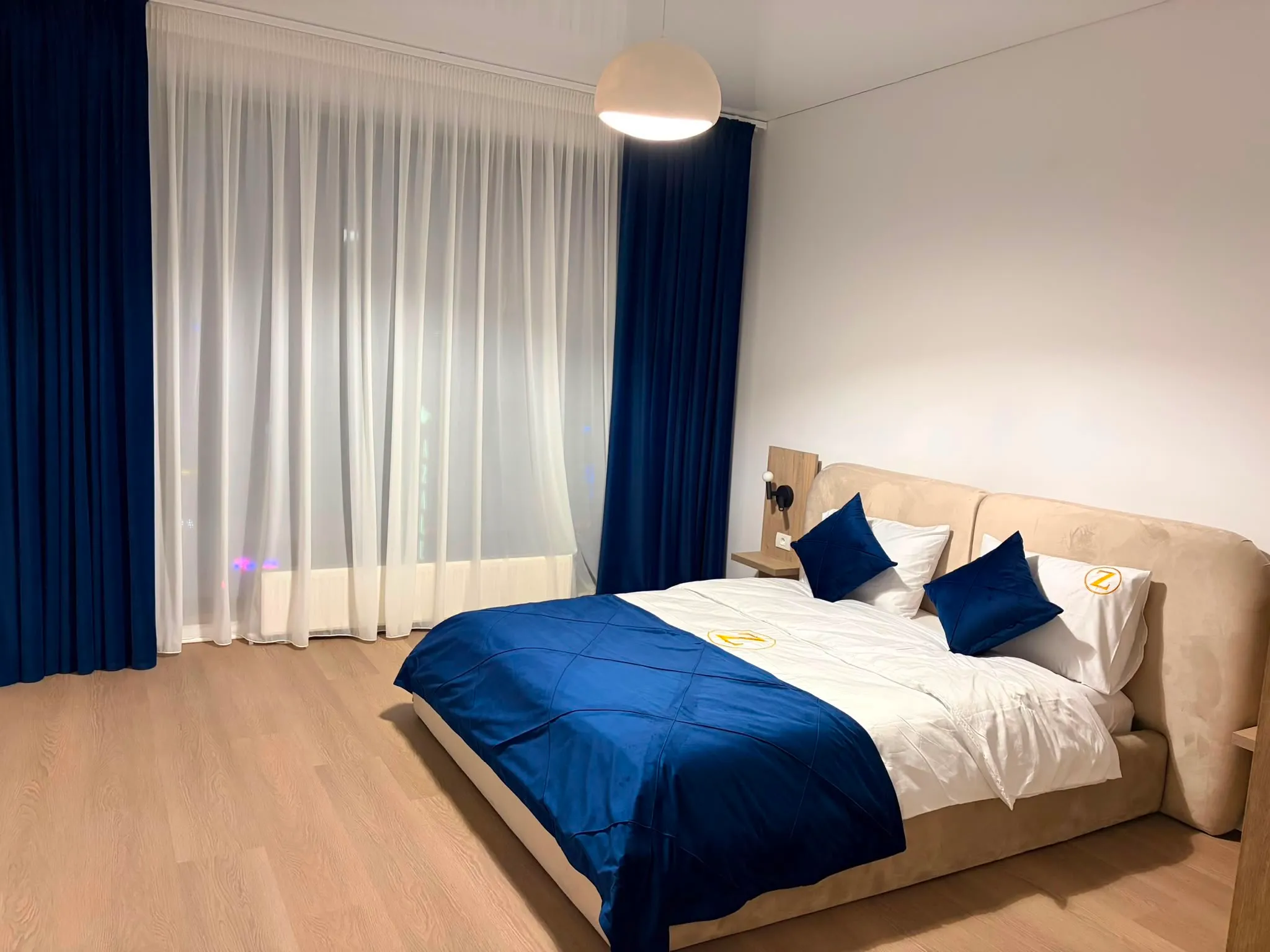 Bedroom dressed in deep navy bedding with matching curtains